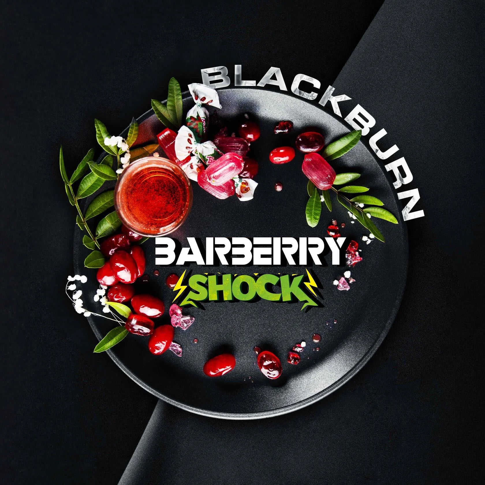 Blackburn Barberry Shock drink surrounded by barberries and green leaves on a black plate