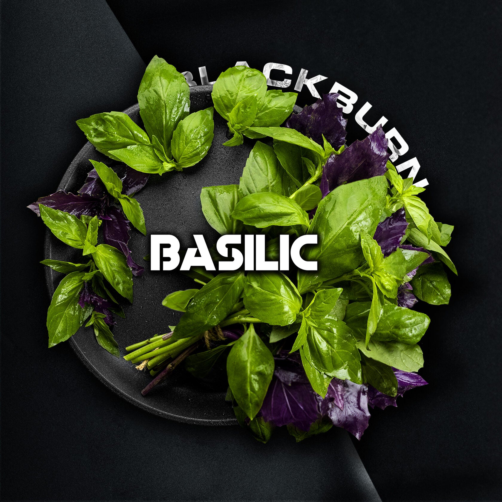 Fresh green and purple basil leaves arranged in a circular pattern on a black plate by LE TABAC