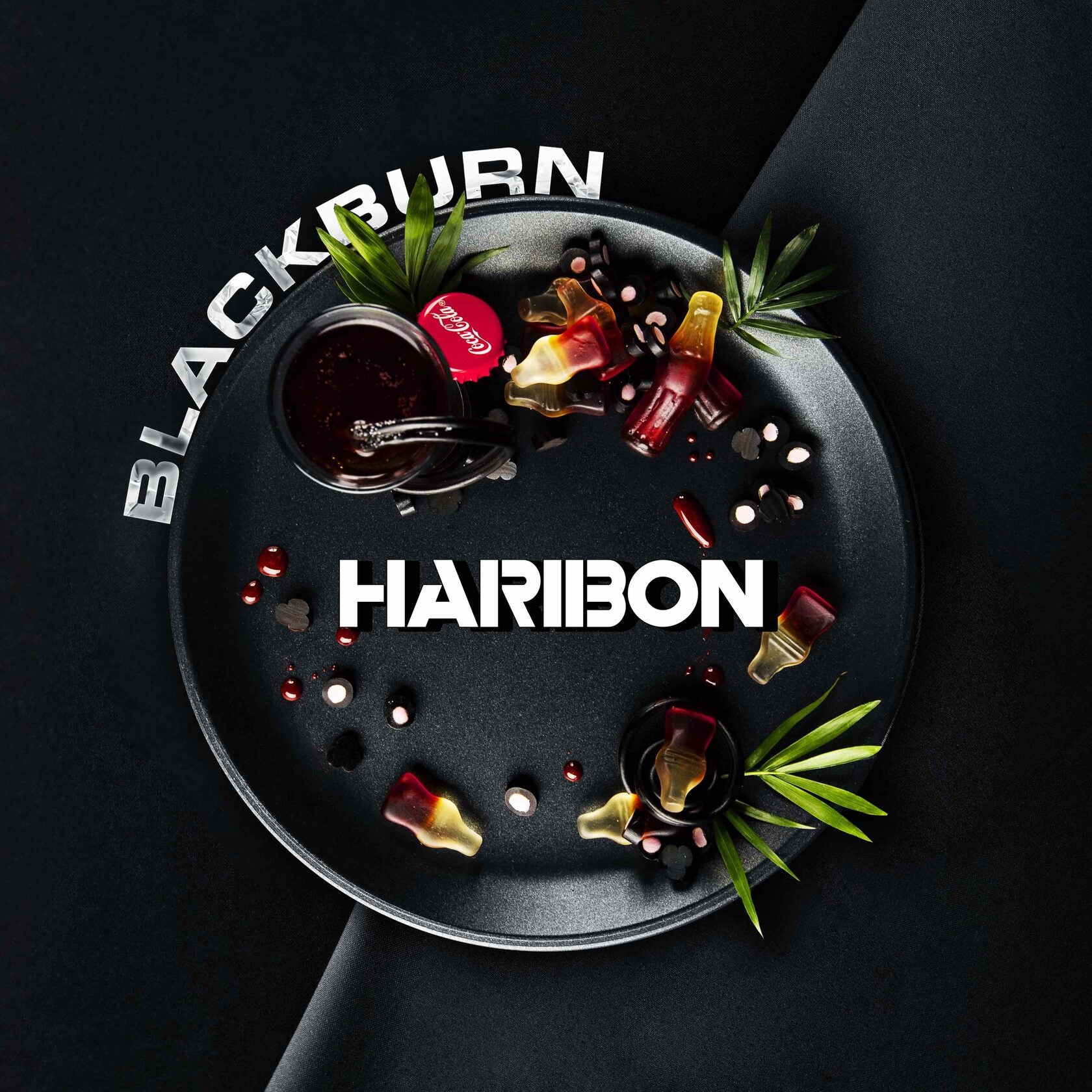 Blackburn Haribon candies with cola bottle gummies and round black and white tablets on a black plate