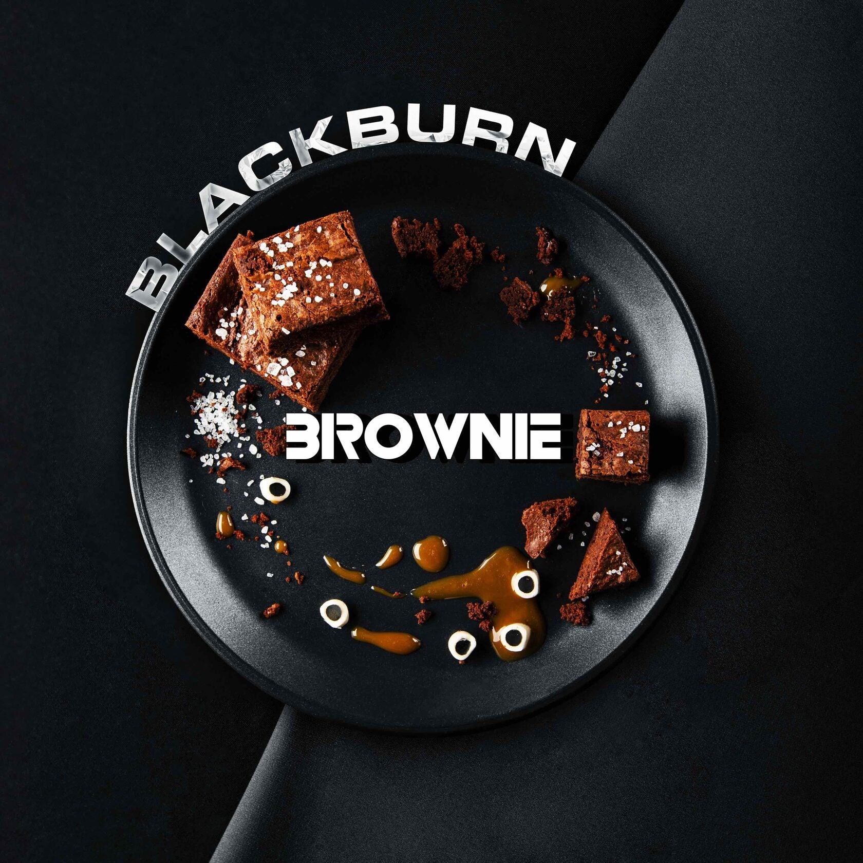 Blackburn brownie pieces on a black plate with caramel sauce and sea salt sprinkled around