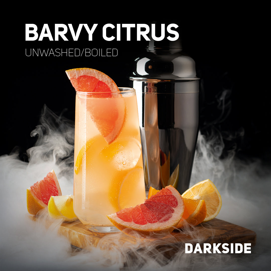 Barvy Citrus cocktail with grapefruit and lemon slices next to a black cocktail shaker on wooden board