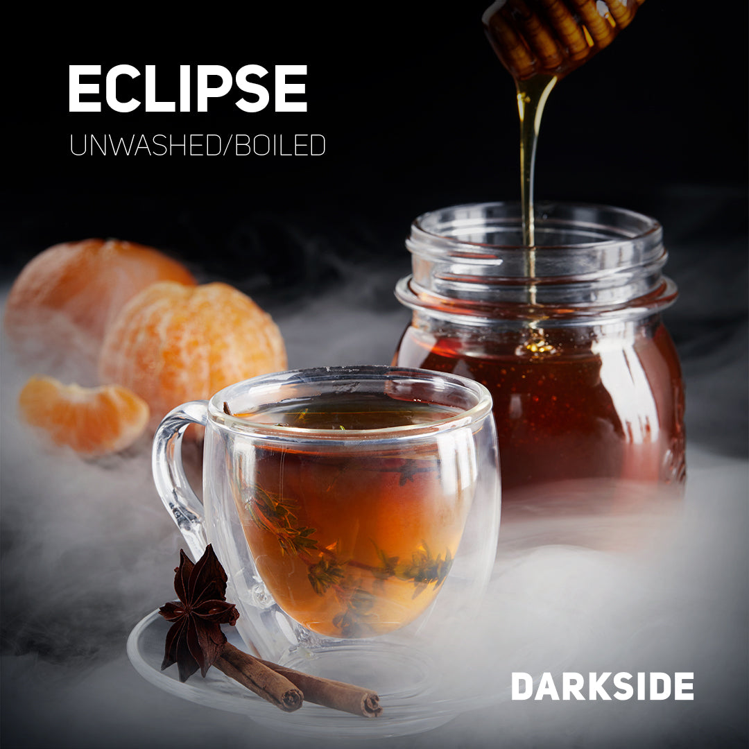Glass cup of dark tea with herbs, cinnamon, star anise, jar of honey pouring, and tangerine slices in background