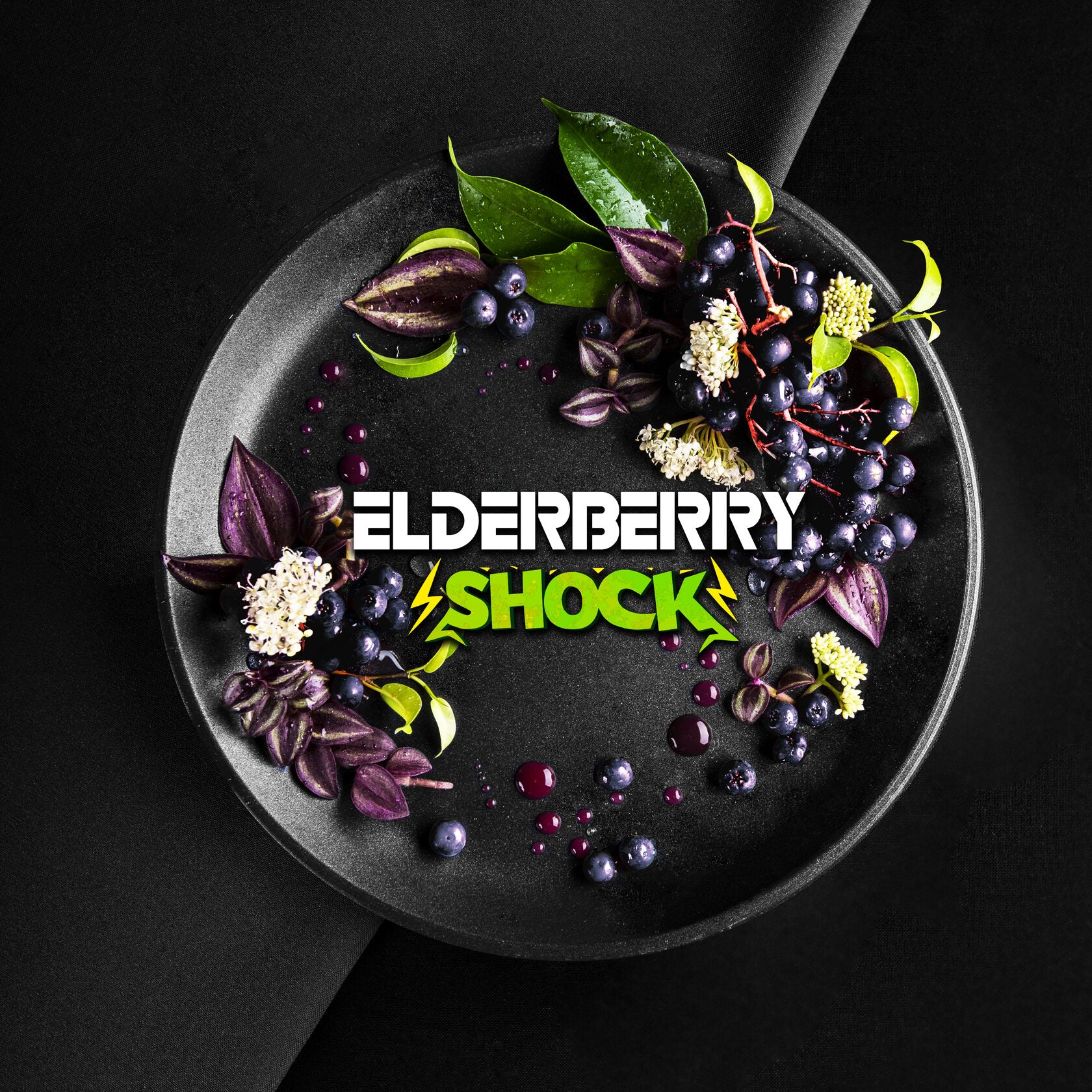 Elderberry shock logo on a black plate decorated with elderberries, green leaves, and white flowers